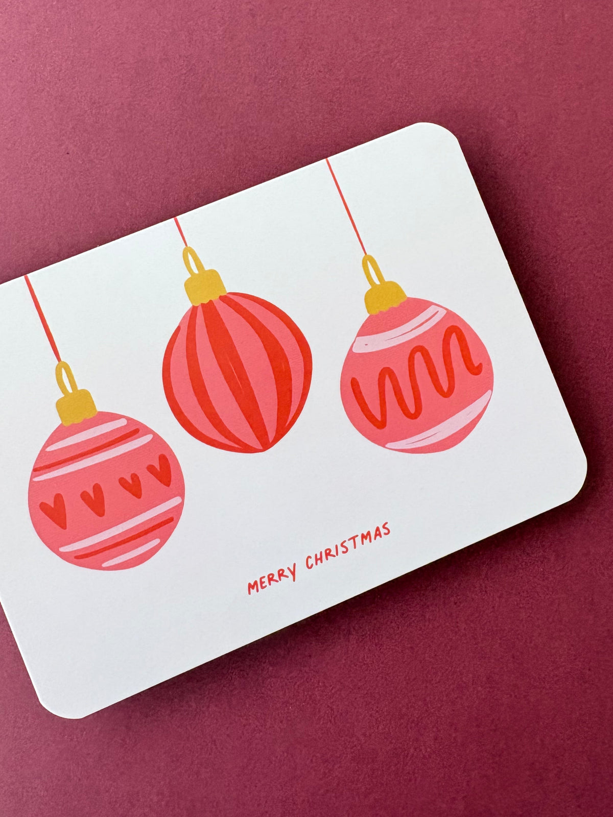Leuke kerstkaart met illustratie van 3 rode kerstballen