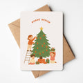 Kerstkaart met illustratie van kinderen onder een boom die versiering ophangen