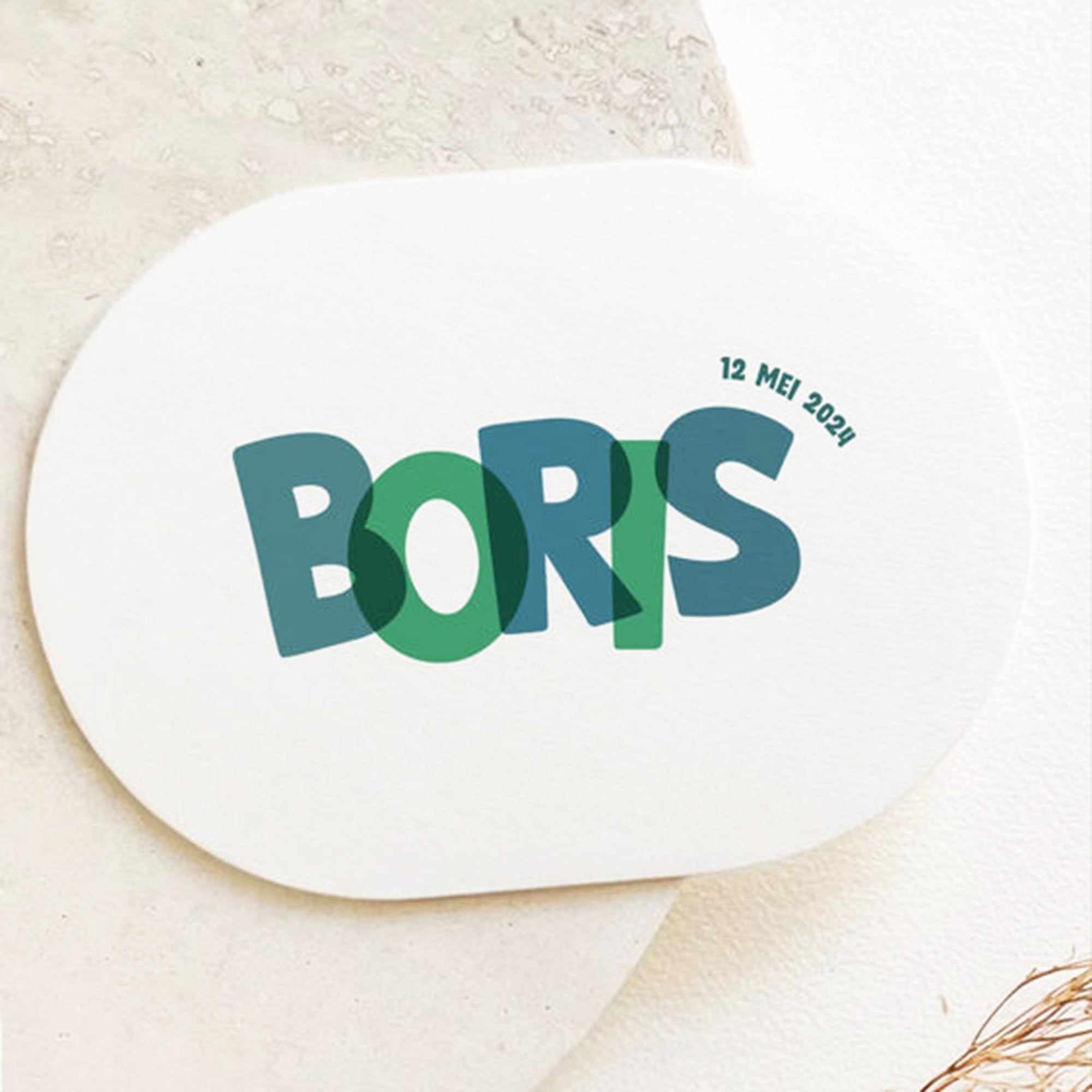 Ovaal geboortekaartje met de naam Boris in blauwe en groene overlappende letters, speelse uitstraling