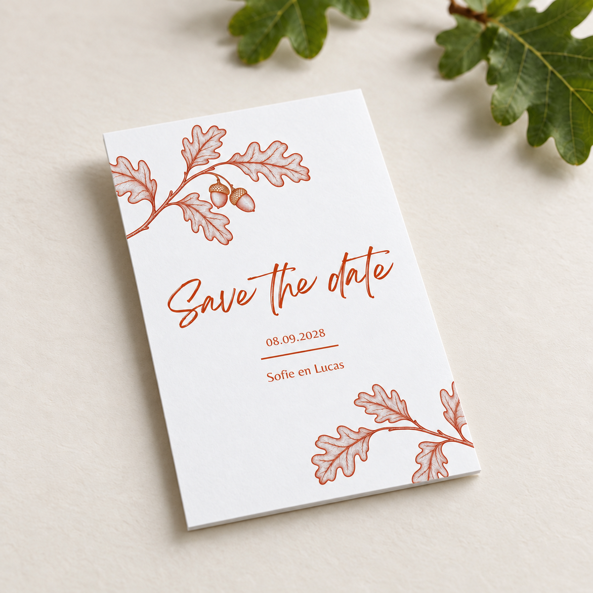 Flatlay van save the date kaart herfst huwelijk met eikels en eikenblad